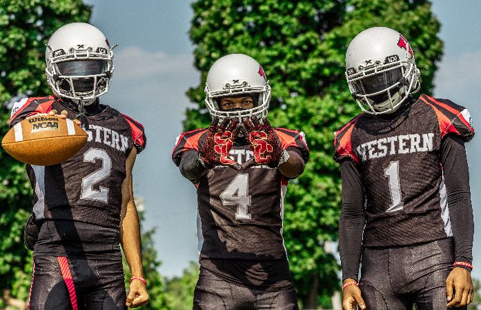 Three Western Football players posing on Media Day