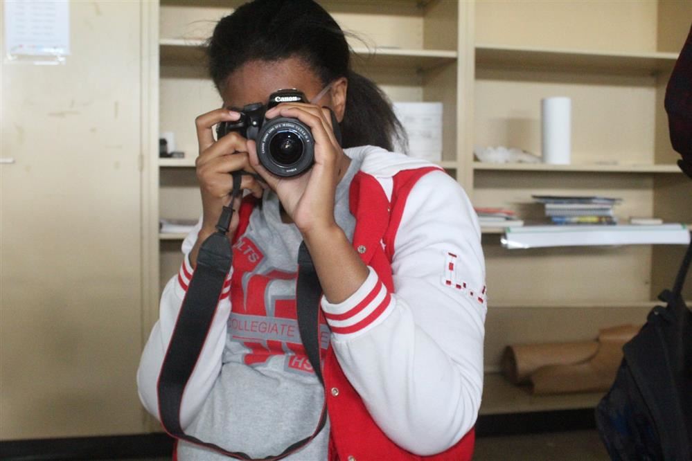 Image of student taking a picture with a camera Image of student taking a picture with a camera