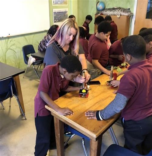 teacher and students working at table