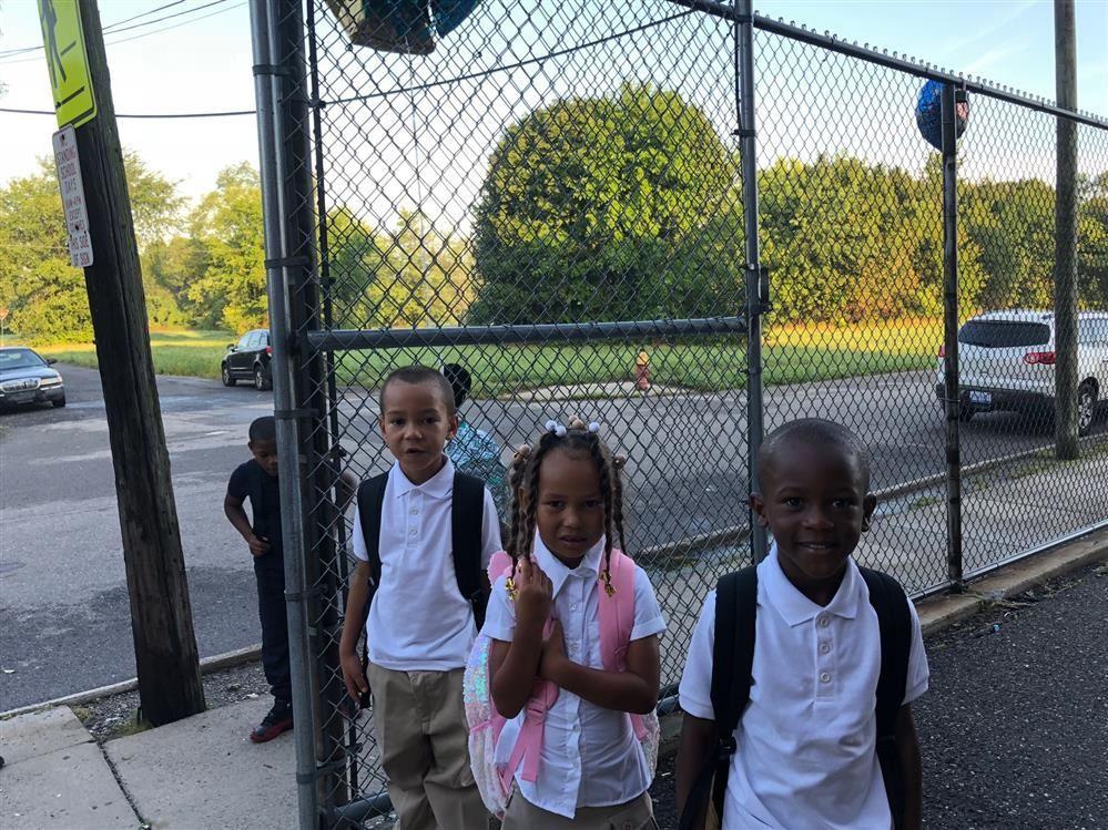 Three students standing outside of school.