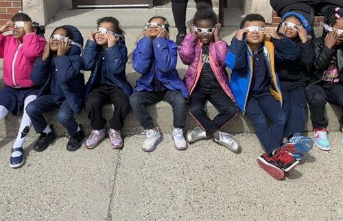 students looking up at the sun