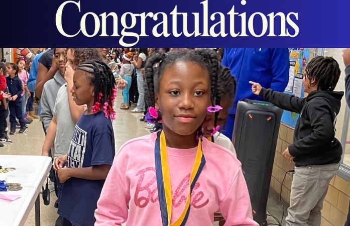   student posing for a picture with their perfect attendance medal