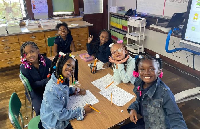  STUDENTS IN CLASS SMILING AND LEARNING