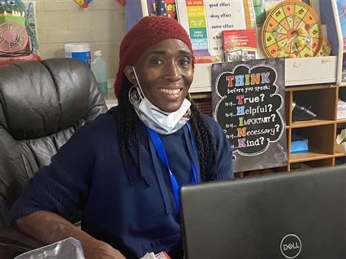 Teacher wearing a red scarf on hand with a blue blouse smiling...