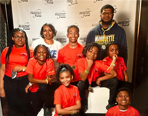 The 2022/23 Chess Team posing with Mrs. Gray & Coach Derek after a tournament win