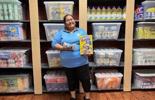 Our Parent coordinator posing in front of our food pantry.
