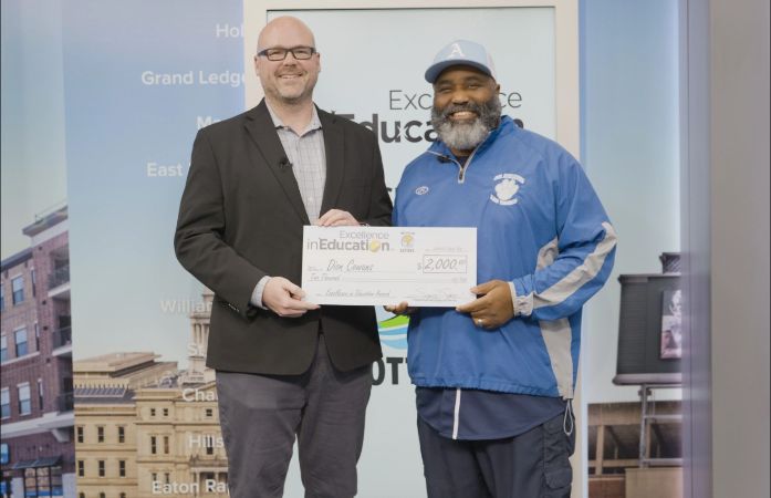  Mr. Cowens posing with a large check for Michigan Lottery