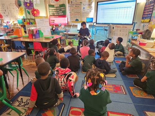 4th Grade student reads to Kindergarten students at Mann