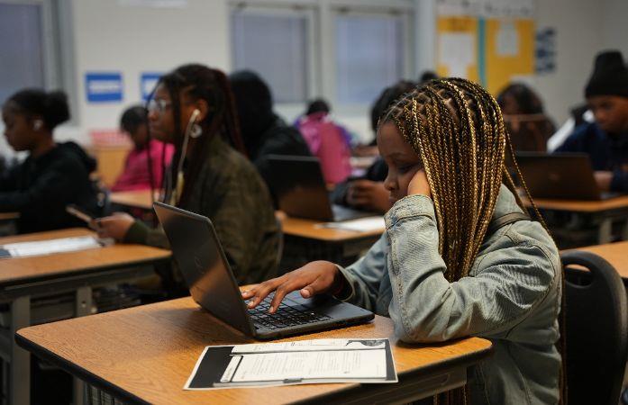 student sitting at a desk working on a laptop
