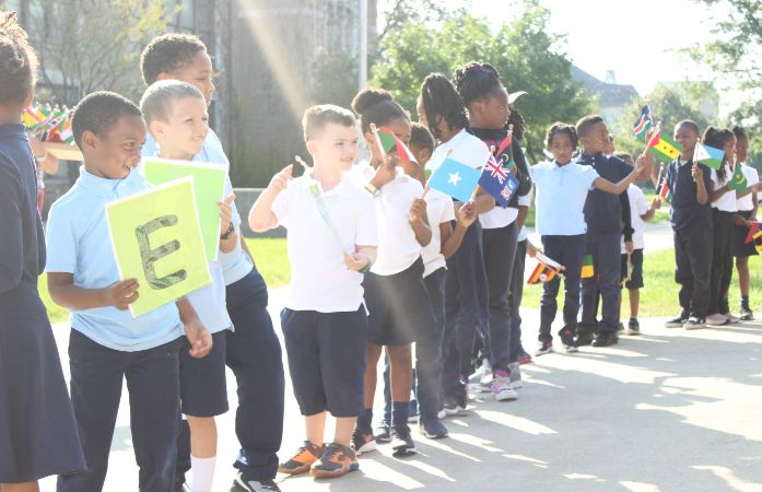  Children lined up outside holding letters that spell out the word peace