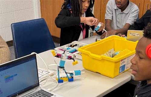 3 students testing their Lego robot