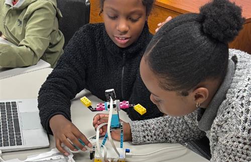 2 girls testing their Lego robot out