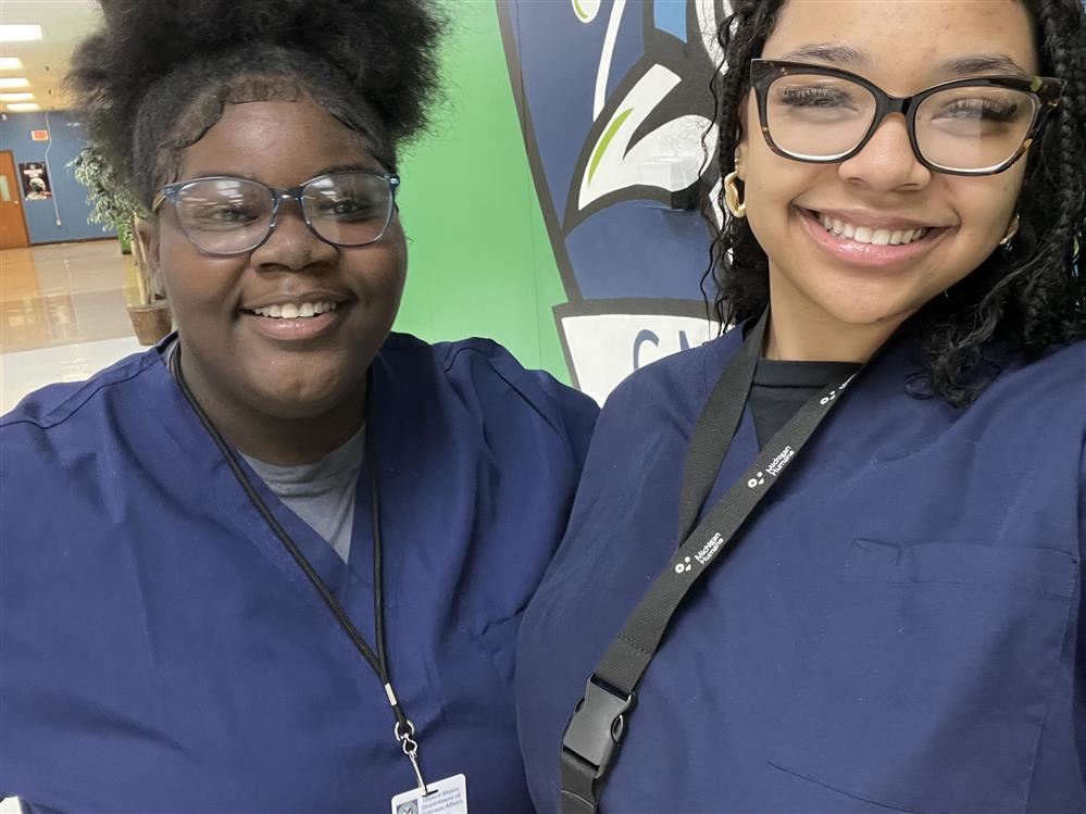  Two students wearing scrubs