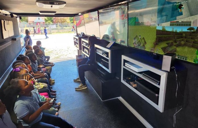 students inside game truck playing video games