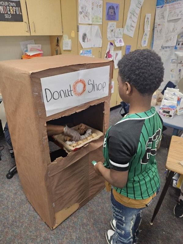  student getting a donut from person in a box