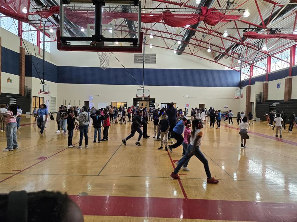  several kids dancing with headphones in a school gym