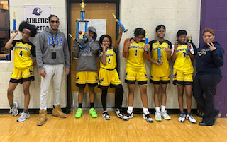  a group of female basketball players with their coach and principal holding a trophy