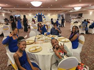  Students dressed nicely and sitting at a fine dinning room