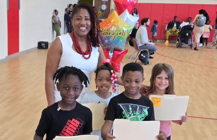  Principal standing with students holding awards.