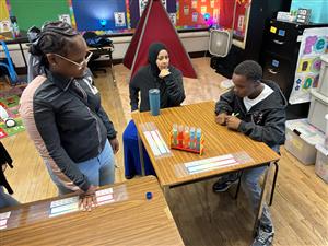 students and staff watching the chemical reaction of 5 different colored bath bombs 
