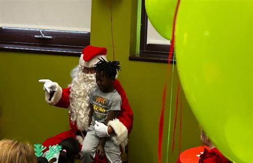Smiling child on Santa's lap.