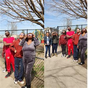 Staff, parents and students look up at the sky