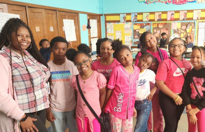Female teacher and students pose for a picture