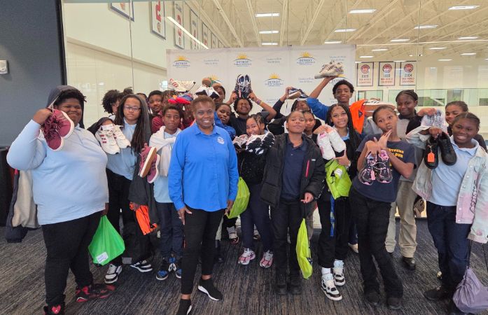  Students standing with Councilwoman holding up shoes.