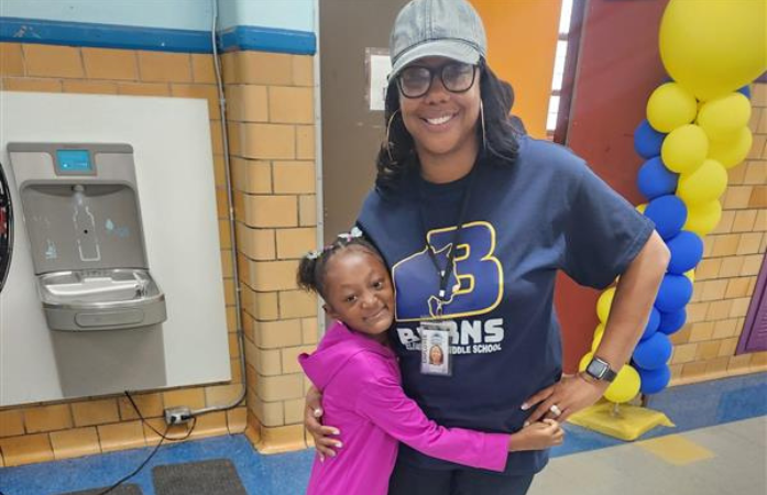  student hugging Principal Clayton