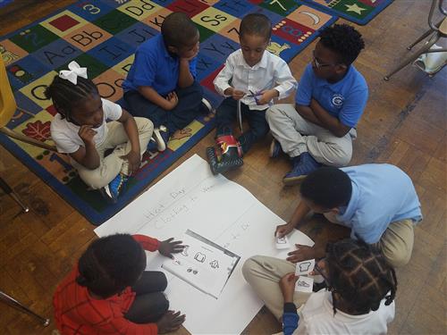  kids sitting on floor working together