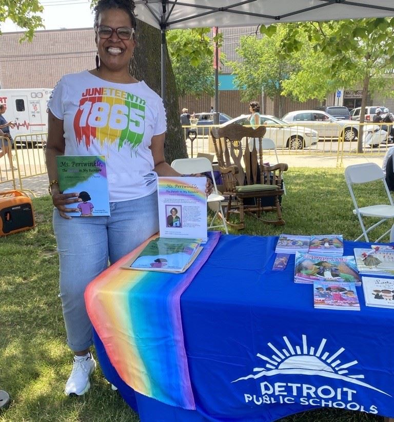 author standing by book table outside author standing by book table outside