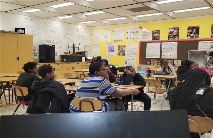 Students sitting in a classroom, looking forward. 