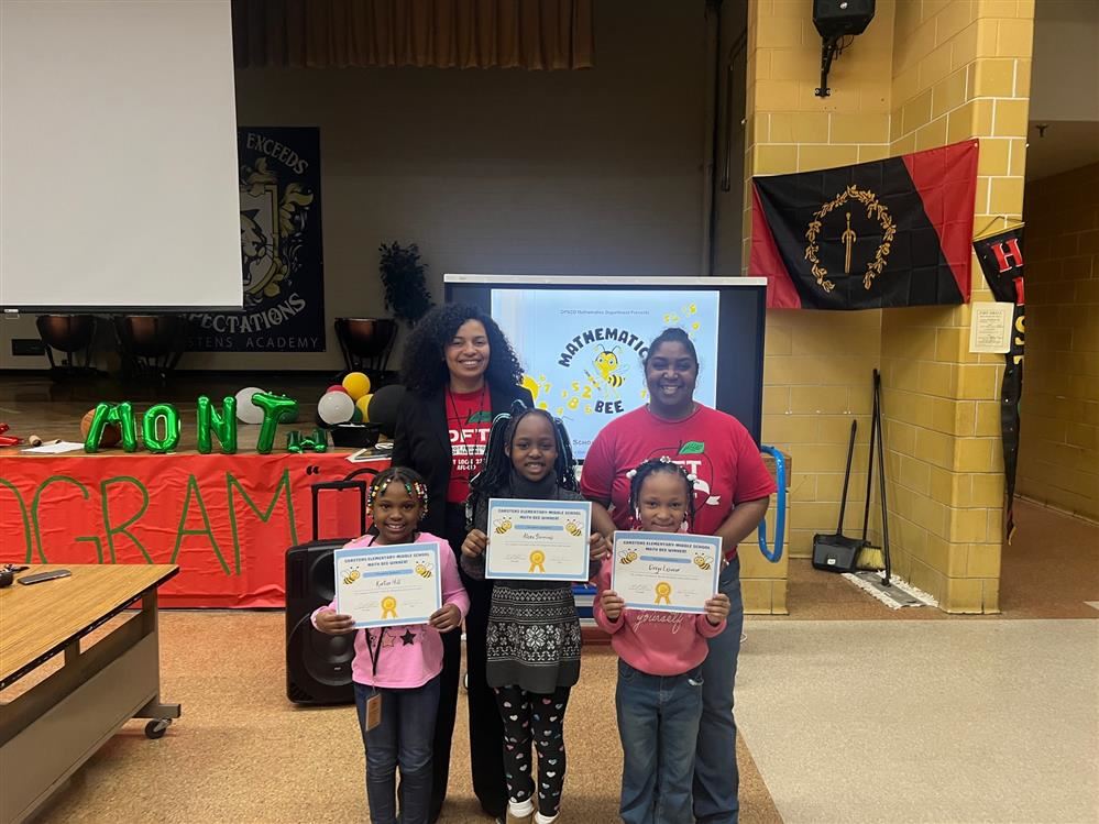 3 students holding a certificate along with 2 staff members. 