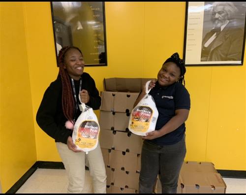 Two students holding turkeys. 