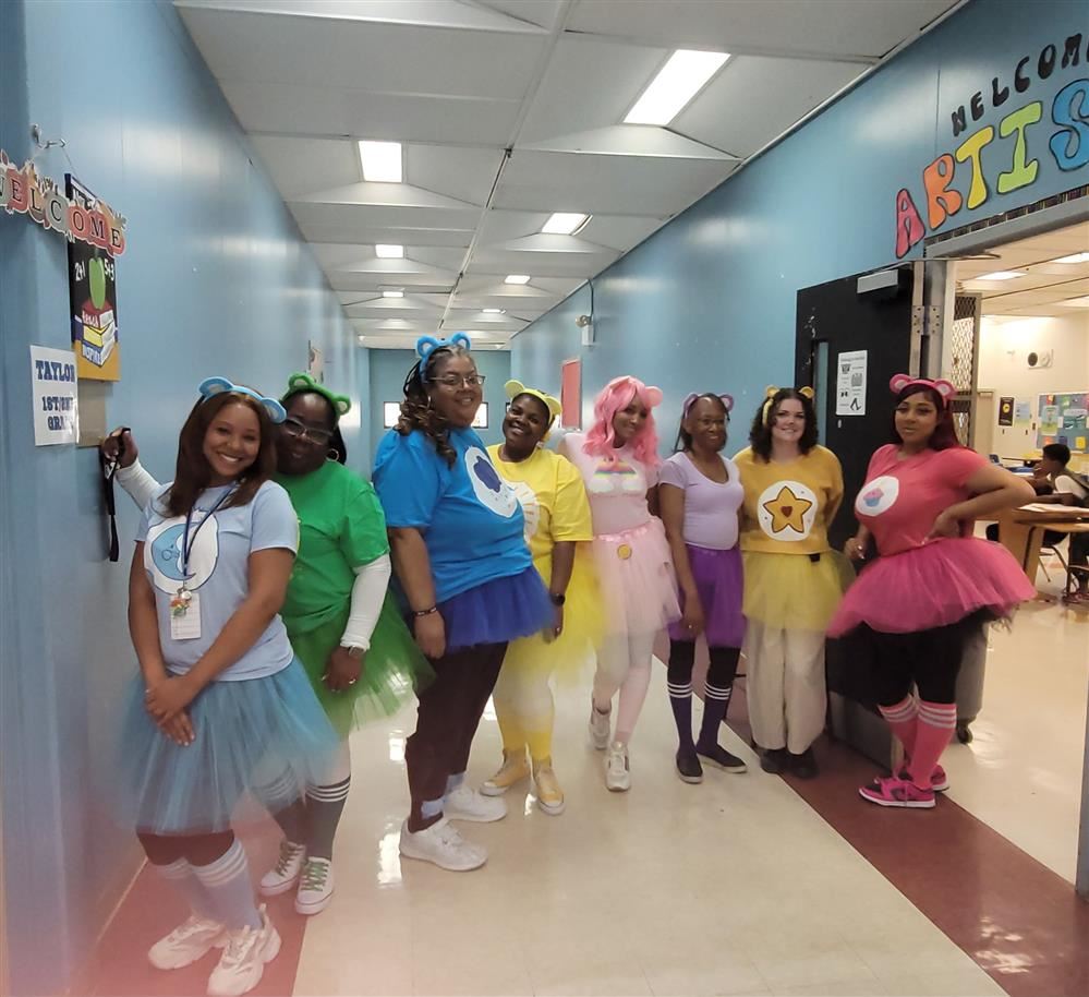  staff members dressed as colorful care-bears for Halloween.