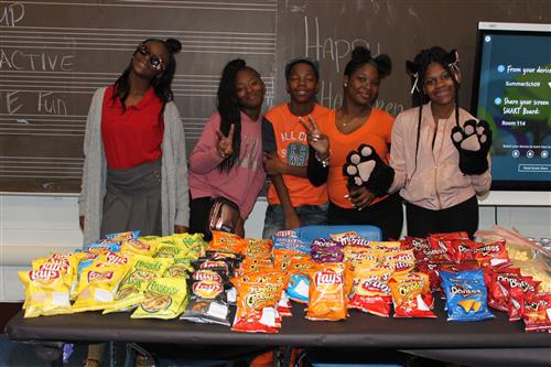  A small group of students pose behind a table of snacks.