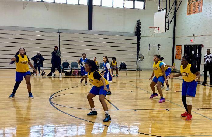 girls basketball team on the court in blue and gold uniforms.