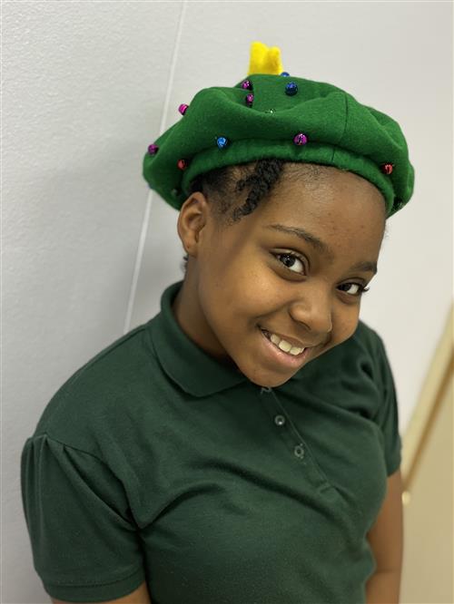 A girl with a big smile wearing a hat.