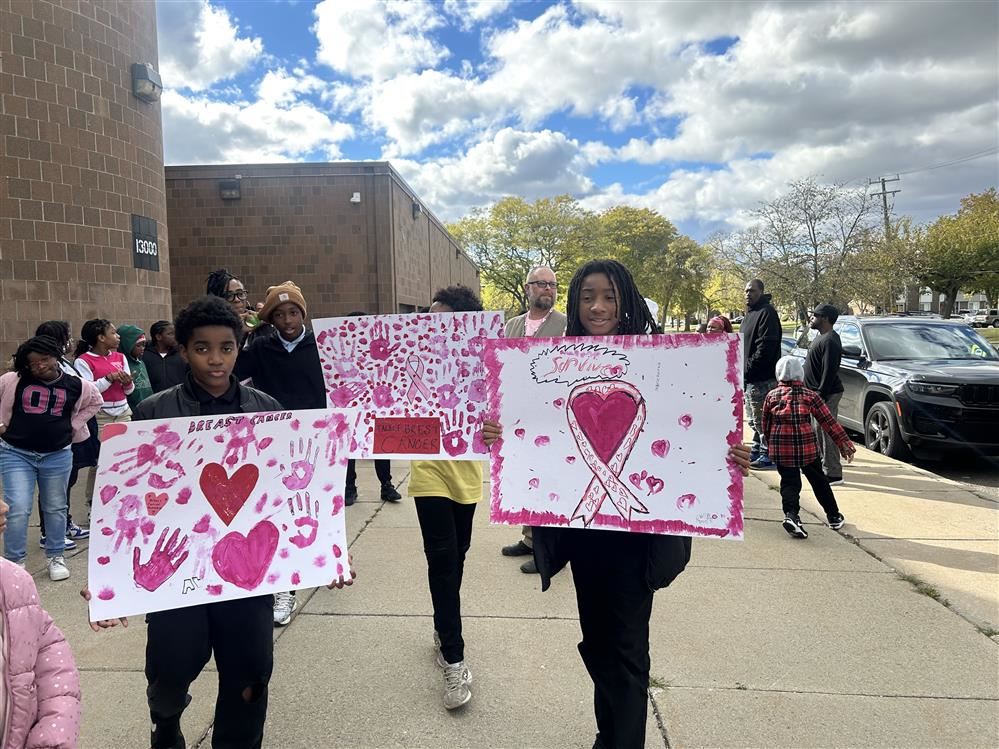  students holding breast cancer signs.