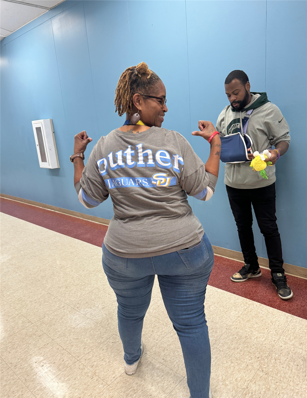 woman facing backwards pointing to her southern university tshirt