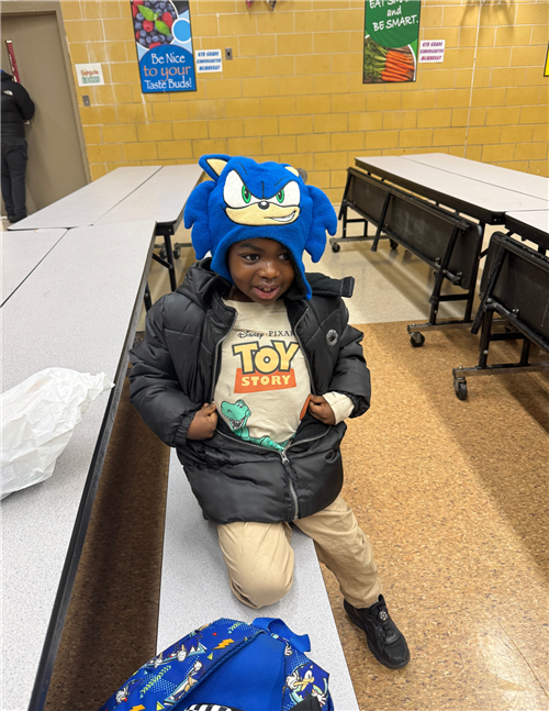 young boy wearing a toy story shirt and sonic hat