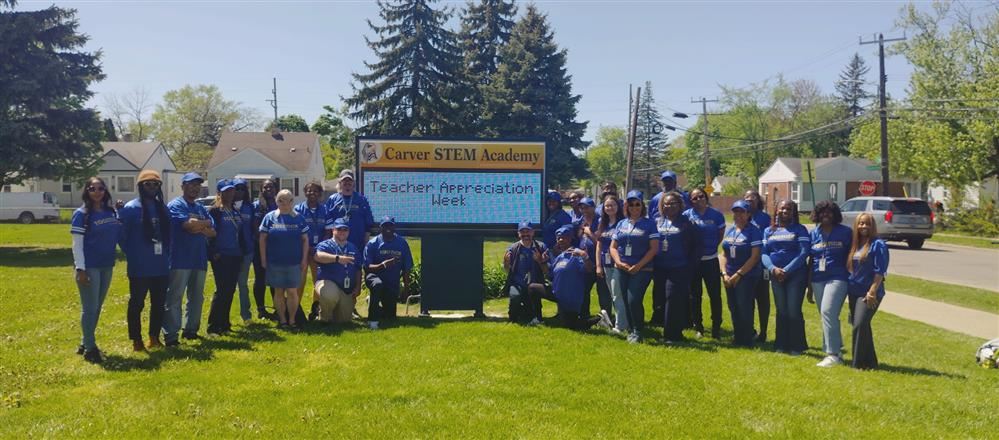  Carver staff wearing jerseys in front of the school's marque