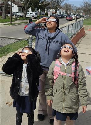 A family uses glasses to watch the eclipse