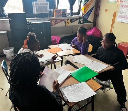 four students working together in a group
