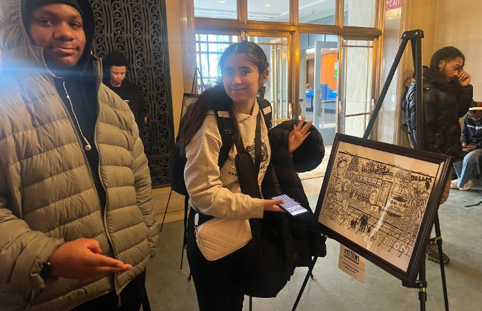  A boy and a girl standing by a person's artwork.