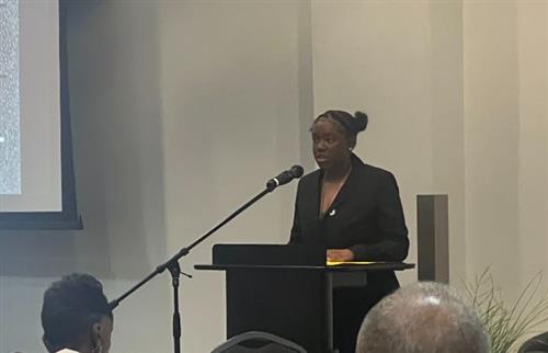  A girl standing and speaking to a group 