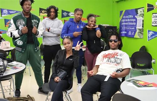 Six students in a classroom with a green wall