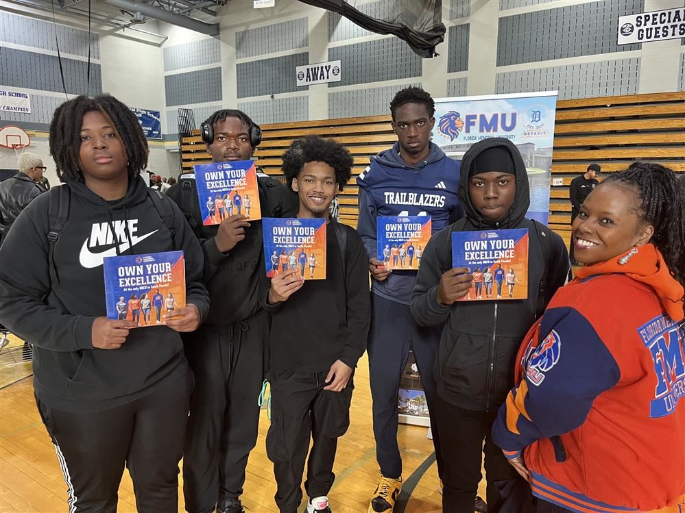  Students holding a sign "Own your excellence"