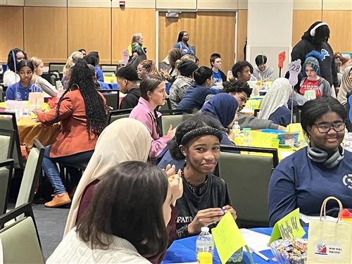 Students sitting at various tables at the conference.