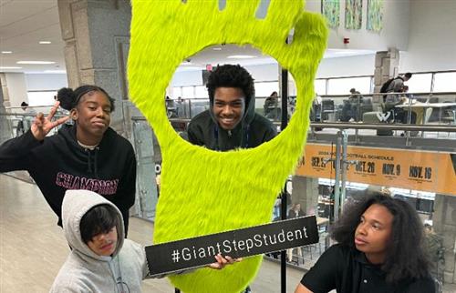 Students taking a picture the Giant Step Student display